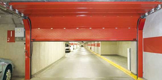 Противопожарные секционные ворота красного цвета на подземной автостоянке
